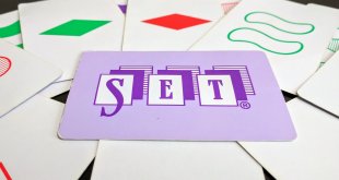 Several set cards arranged on a table with one card featuring the word Set prominently