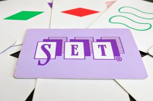 Several set cards arranged on a table with one card featuring the word Set prominently