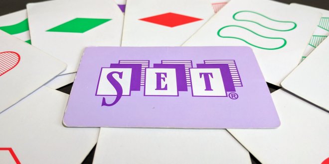 Several set cards arranged on a table with one card featuring the word Set prominently