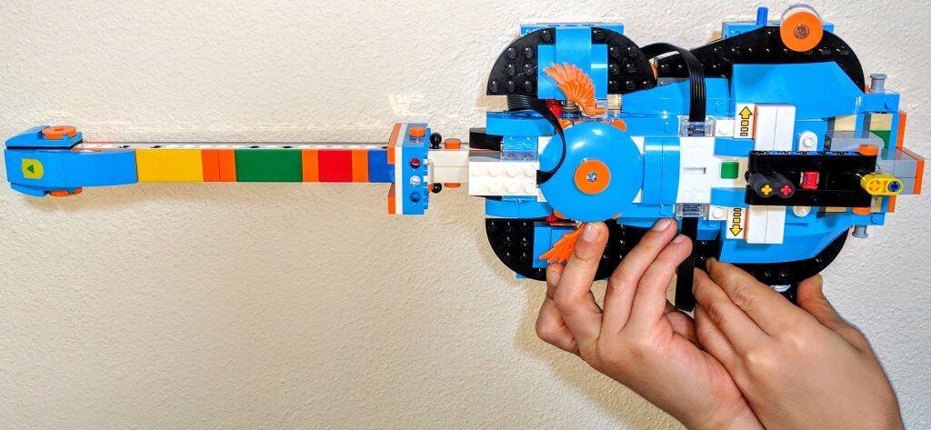 boy's hands holding a LEGO guitar made from the LEGO Boost set